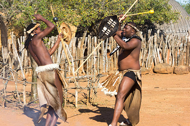 istockphoto-504510595-612x612 Eshowe, South Africa - May 24, 2014: Zulu men dressed in traditional or tribal dress performing a display of Zulu stickfighting with knobkerries at a Zulu kraal near Eshowe in Zululand.